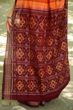 Load image into Gallery viewer, Handloom drape view of orange Sambalpuri Bandha saree by Pasapali, GI-tagged Odisha ikat weave, deep maroon accents.