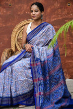 Load image into Gallery viewer, Indulekha Sambalpuri Bandha saree — flat lay showing full length, white body, blue pallu and border motifs