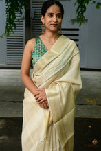 Load image into Gallery viewer, Close-up of golden zari border on natural tussar Sambalpuri silk saree — double ikat weave by Bhulia weavers, Odisha.
