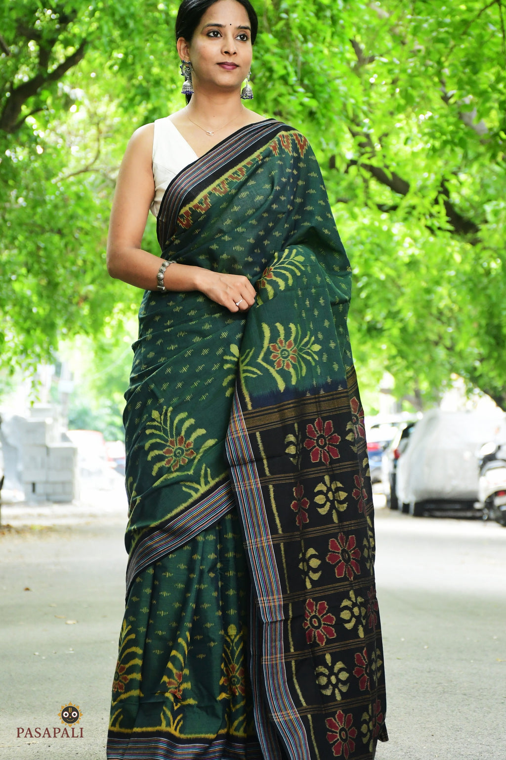Pallu close-up of deep green Sambalpuri saree with multicoloured traditional ikat flower motif, woven by Bhulia weavers.