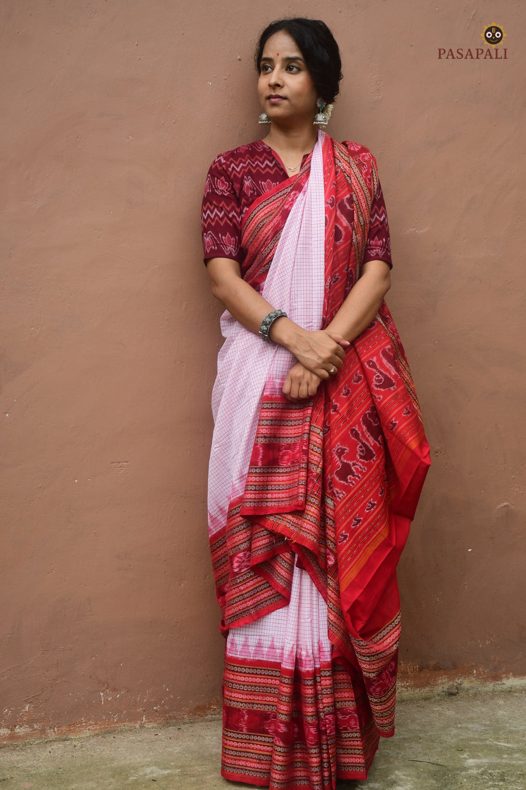 Charushila flat lay — white Sachipar Sambalpuri cotton saree, red dasphulia border, traditional ikat motifs, Pasapali