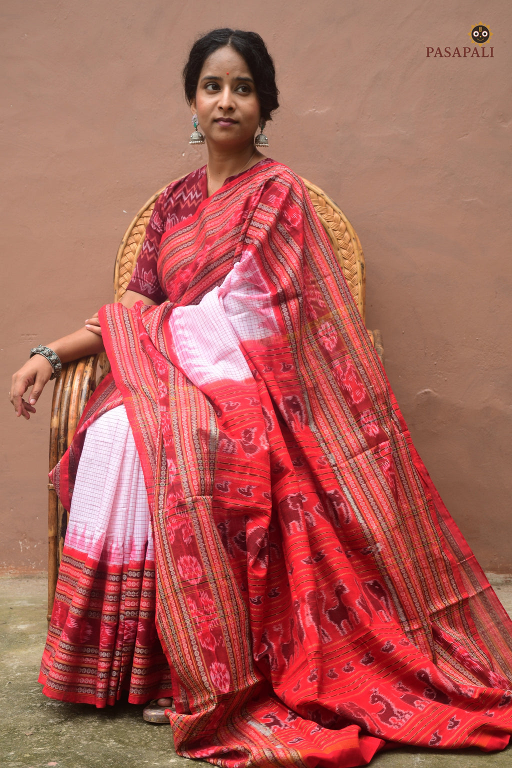 Charushila Sachipar saree front drape — white mercerized cotton, red border, Sambalpuri Bandha weave by Pasapali