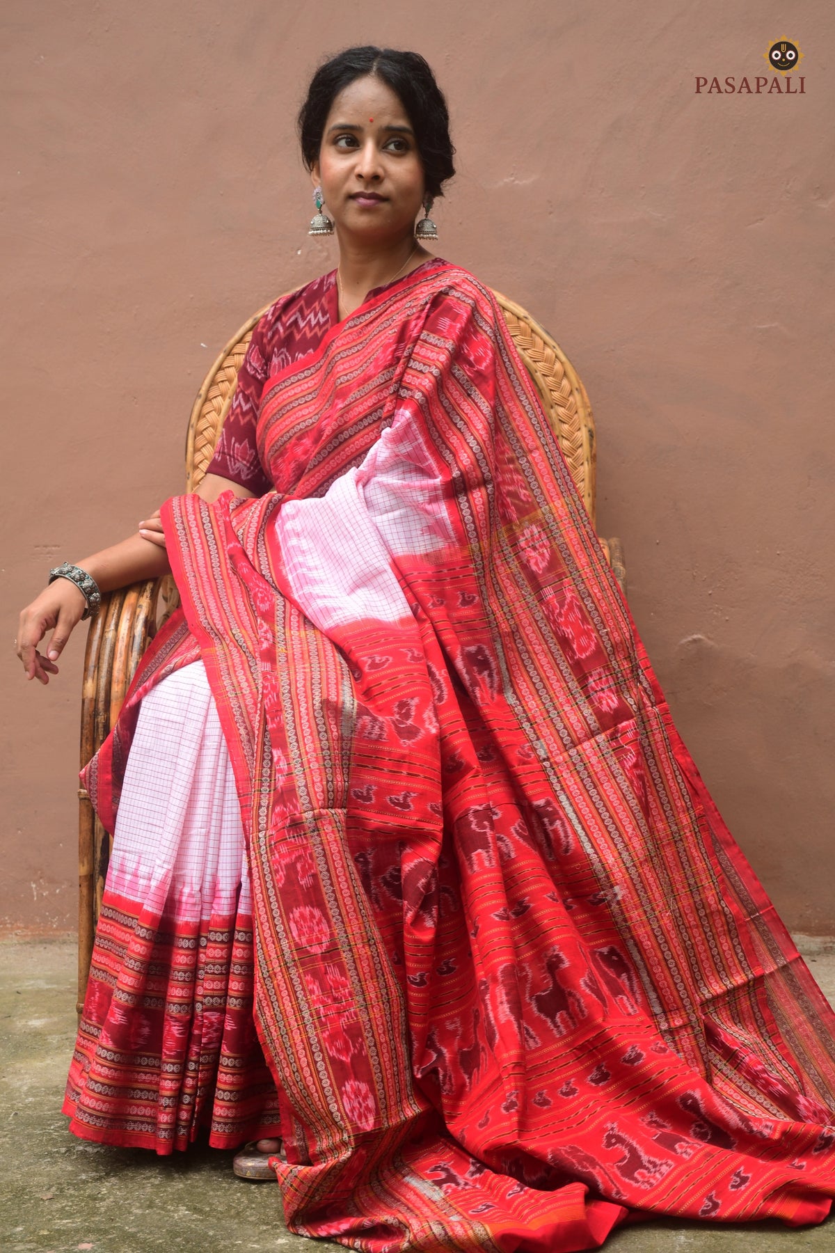 Charushila Sachipar saree front drape — white mercerized cotton, red border, Sambalpuri Bandha weave by Pasapali