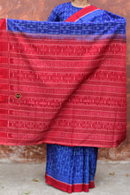 Load image into Gallery viewer, Folded view of Devyani blue Sambalpuri cotton saree showing ikat pallu stripes and red border — Pasapali
