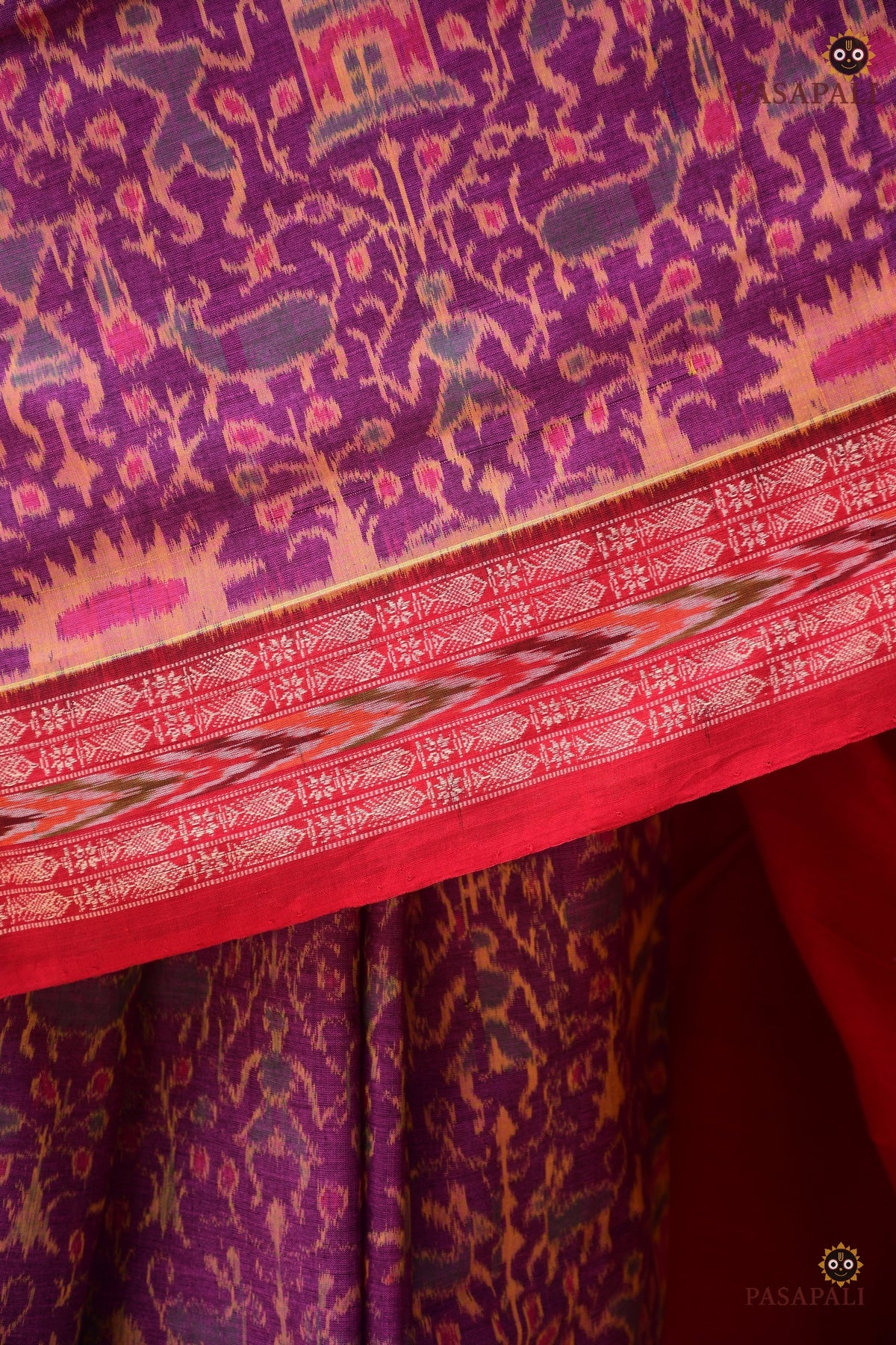 Janapadi drape detail — Sambalpuri Bandha saree in purple with tribal motifs and Konark Chakra pallu. Pasapali.