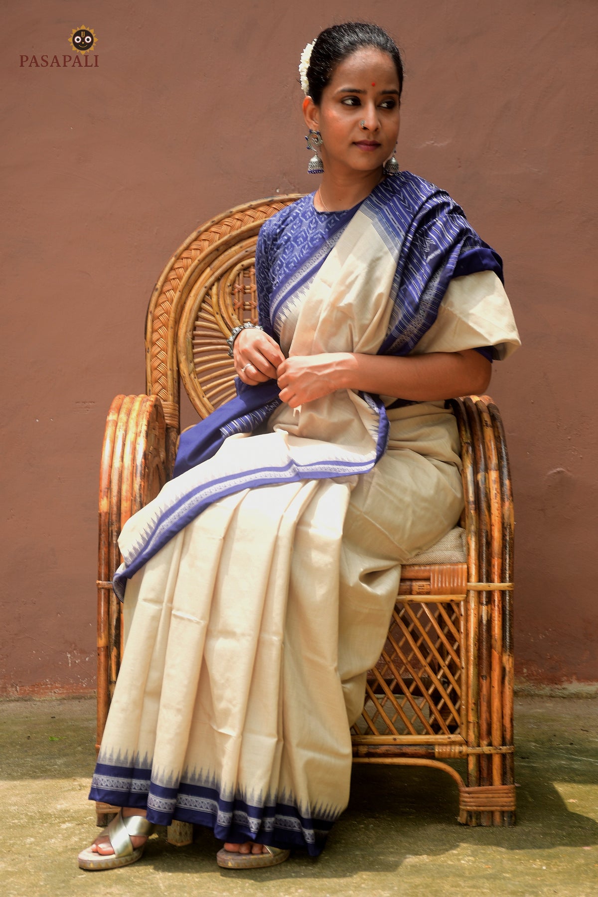 Folded view of Kusumavali off-white Sambalpuri cotton saree showing blue border and phula motif pallu — Pasapali handloom collection
