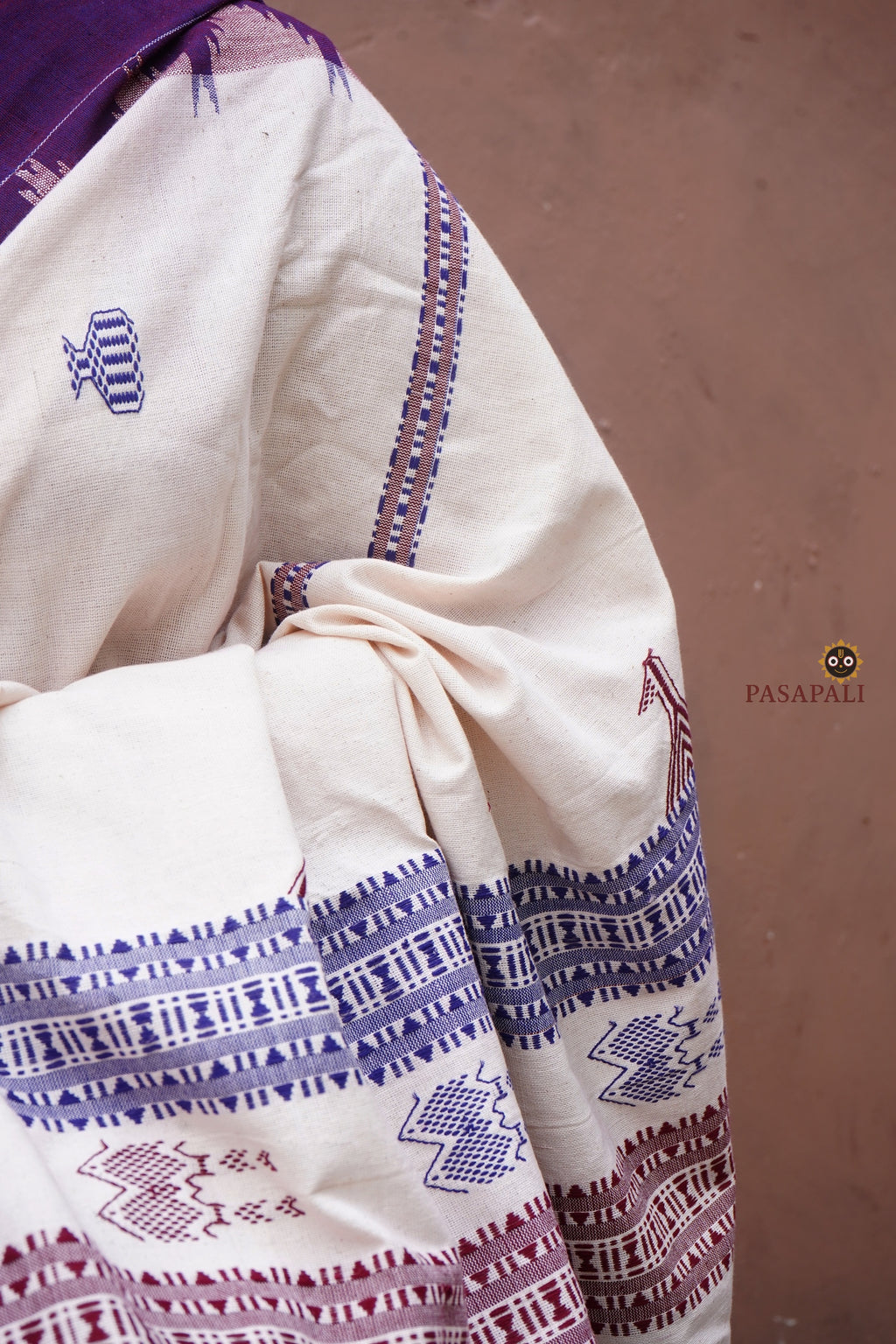 Nirjhari Kotpad natural dye saree folded flat — off-white cotton with purple border, GI certified Kotpad textile