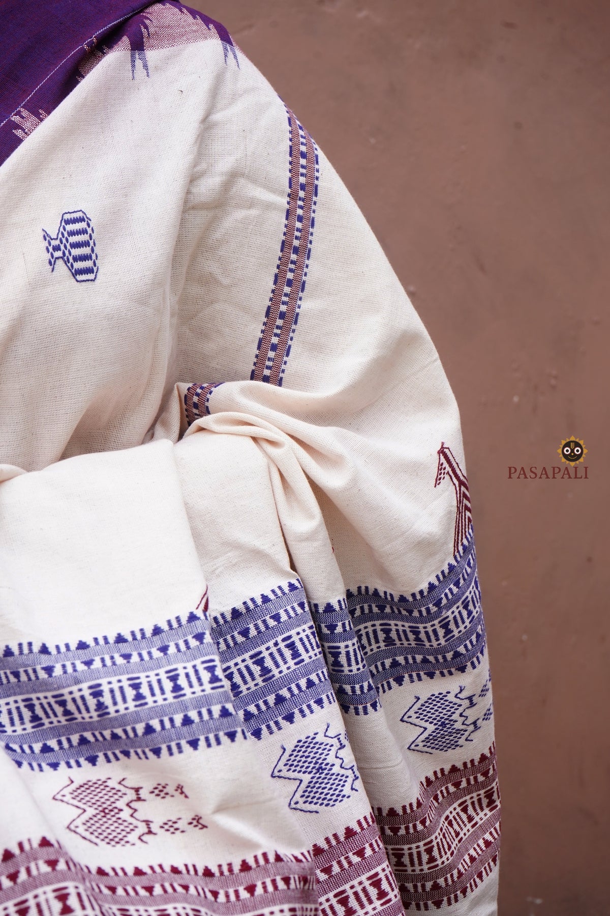 Nirjhari Kotpad natural dye saree folded flat — off-white cotton with purple border, GI certified Kotpad textile