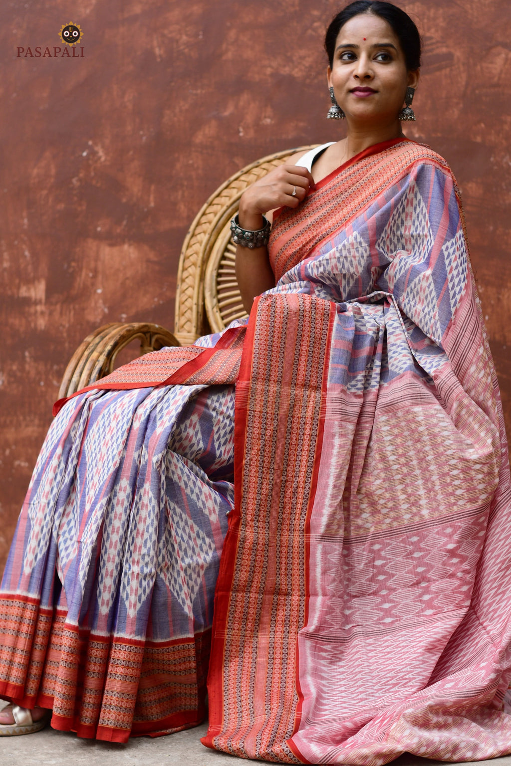 Flat lay of Nityarekha light blue and rust Sambalpuri Bandha mercerized cotton saree — Pasapali handloom