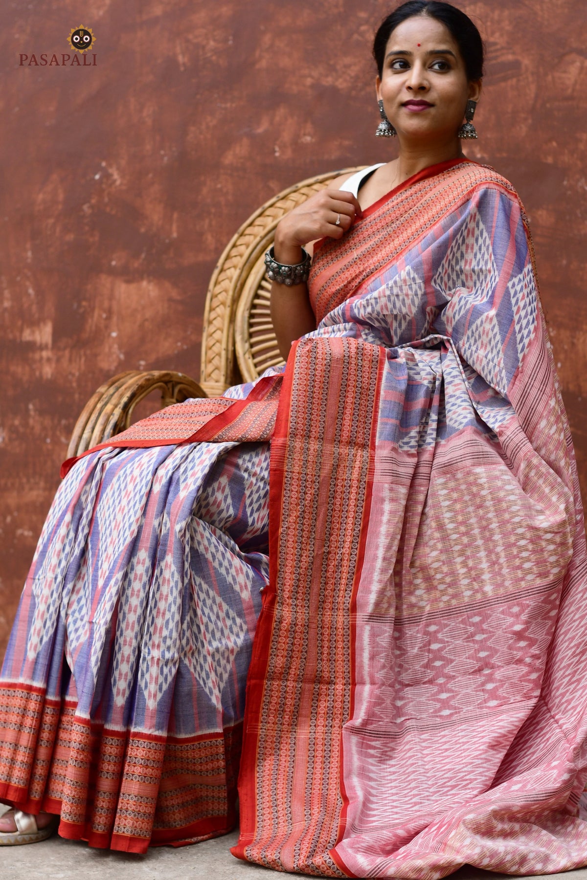 Flat lay of Nityarekha light blue and rust Sambalpuri Bandha mercerized cotton saree — Pasapali handloom