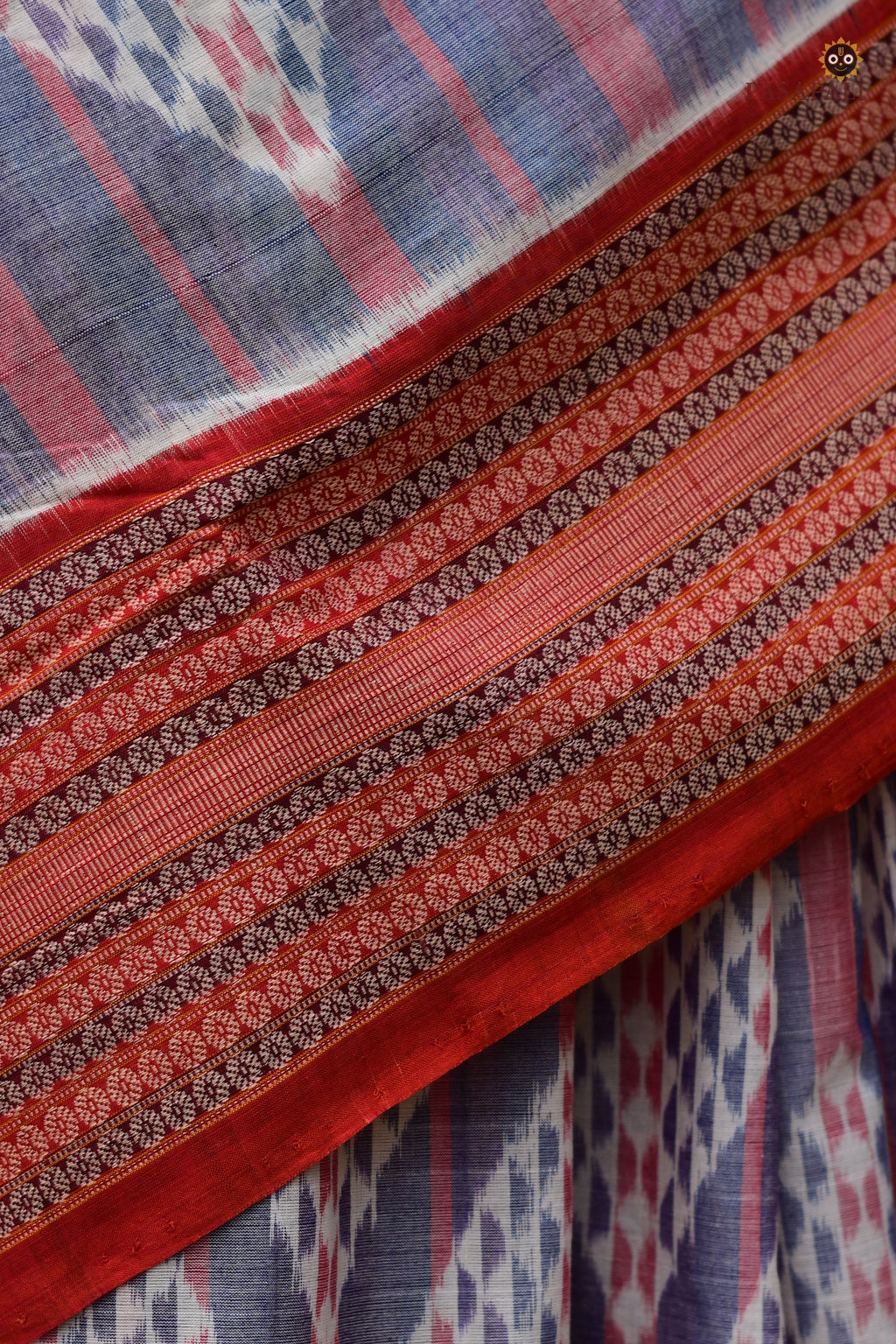 Nityarekha light blue Sambalpuri handloom saree folded showing pallu ikat geometry and rust double border