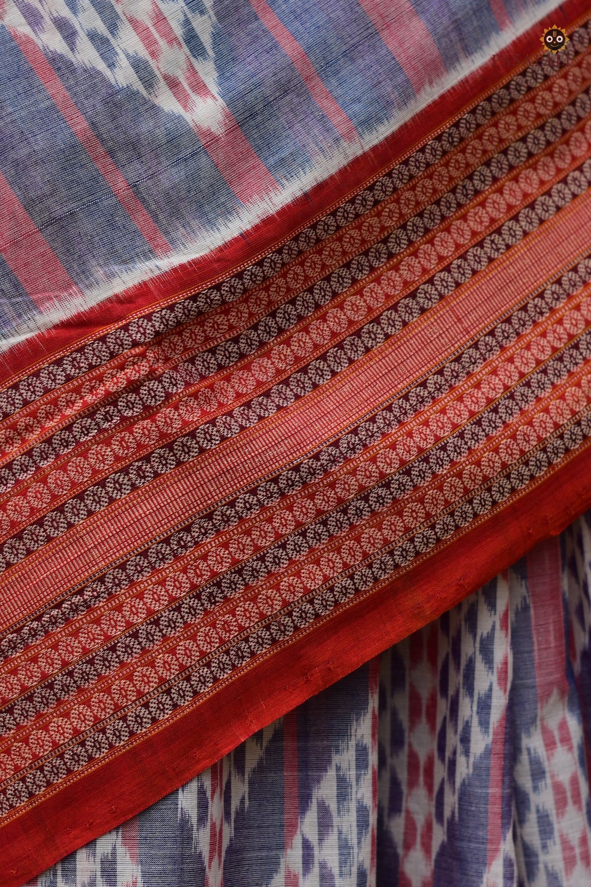 Nityarekha light blue Sambalpuri handloom saree folded showing pallu ikat geometry and rust double border