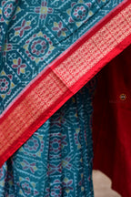 Phuljaal teal blue Sambalpuri Bandha cotton saree — neatly folded showing border and body