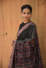 Load image into Gallery viewer, Purvasha Black Sambalpuri cotton Bandha saree folded — fish border and jala checks visible, GI certified, Pasapali
