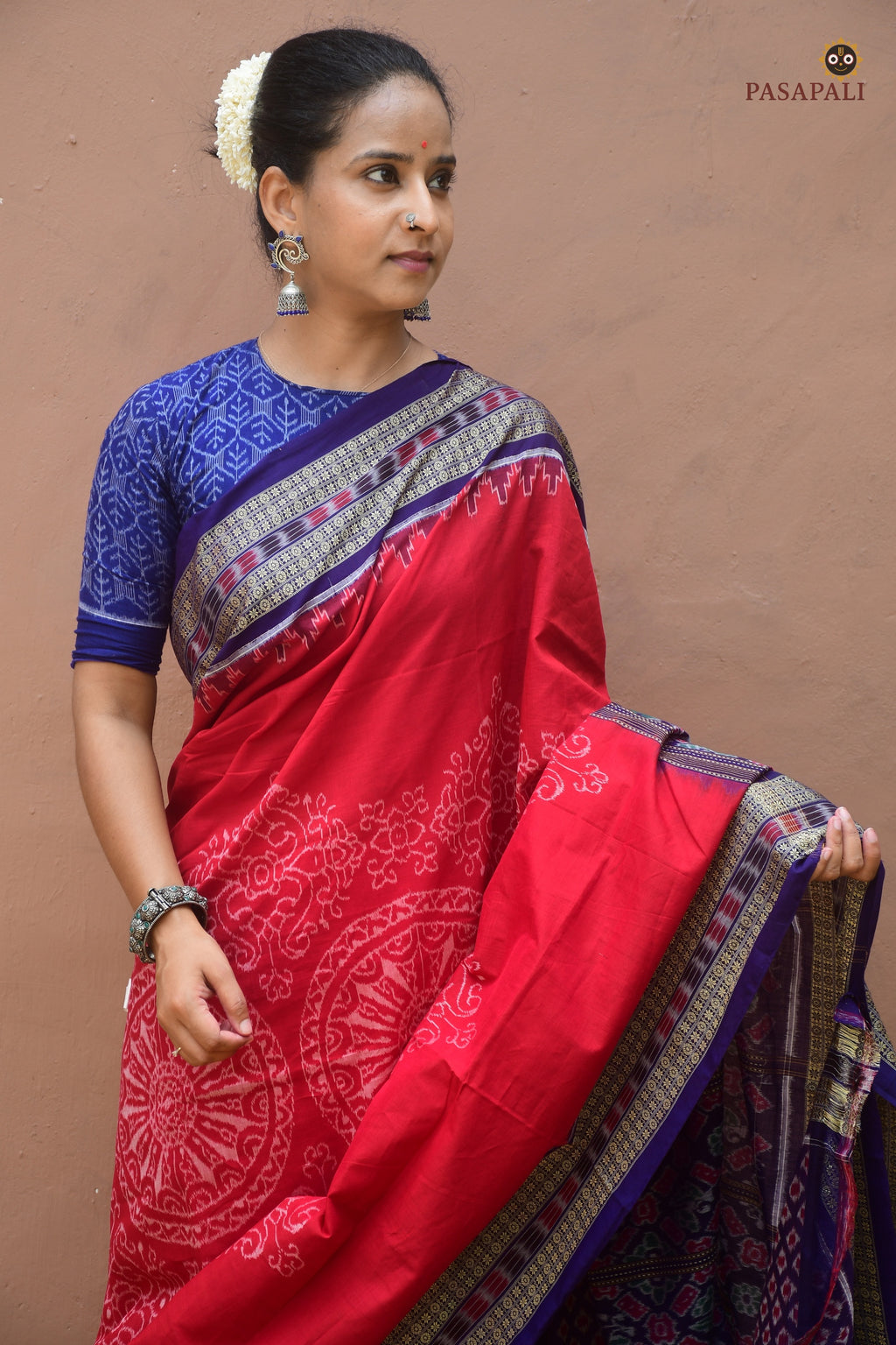 Flat lay of Ratnaprabha red Sambalpuri Bandha saree by Pasapali — chakra body, rudraksha border, phula pallu visible