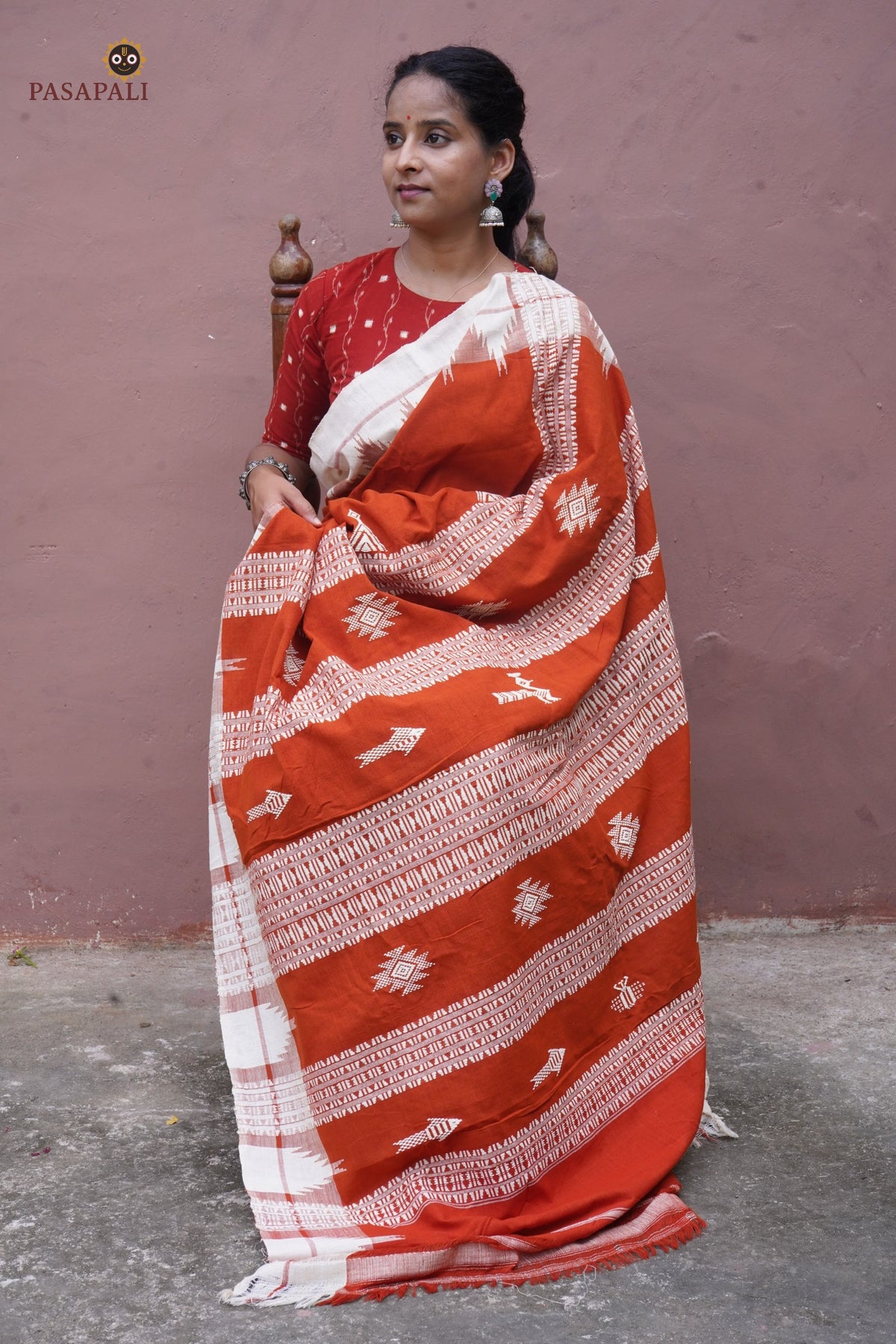 Flat lay of Shalmali Kotpad saree — orange natural dye cotton, kumbha border, tribal motifs, Pasapali