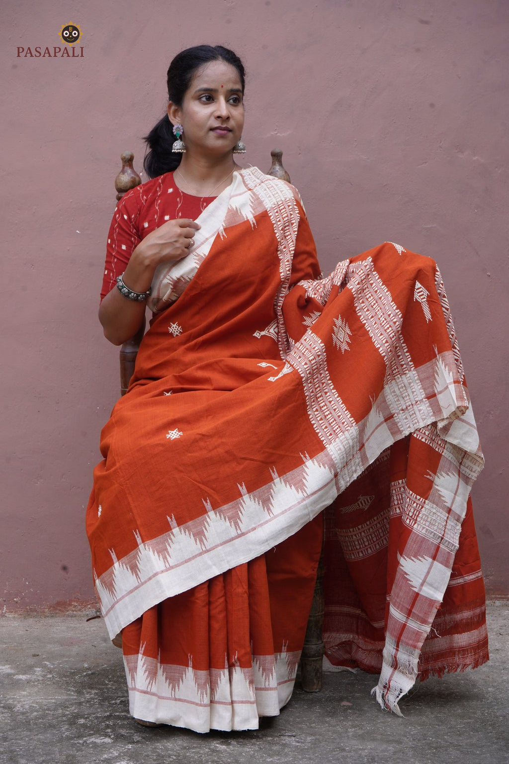 Kumbha border close-up on Shalmali Kotpad saree — multi-shuttle interlocking raised temple form, orange cotton