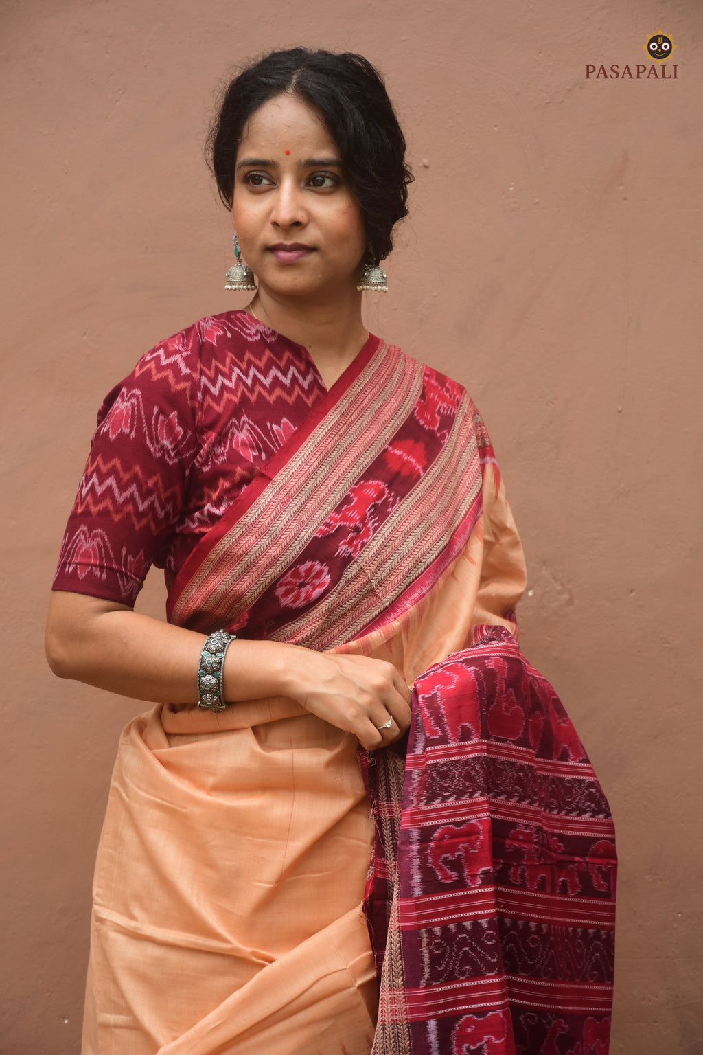 Sunanda Sambalpuri cotton saree folded flat — light brown with maroon ikat border and GI certified Sambalpuri craft